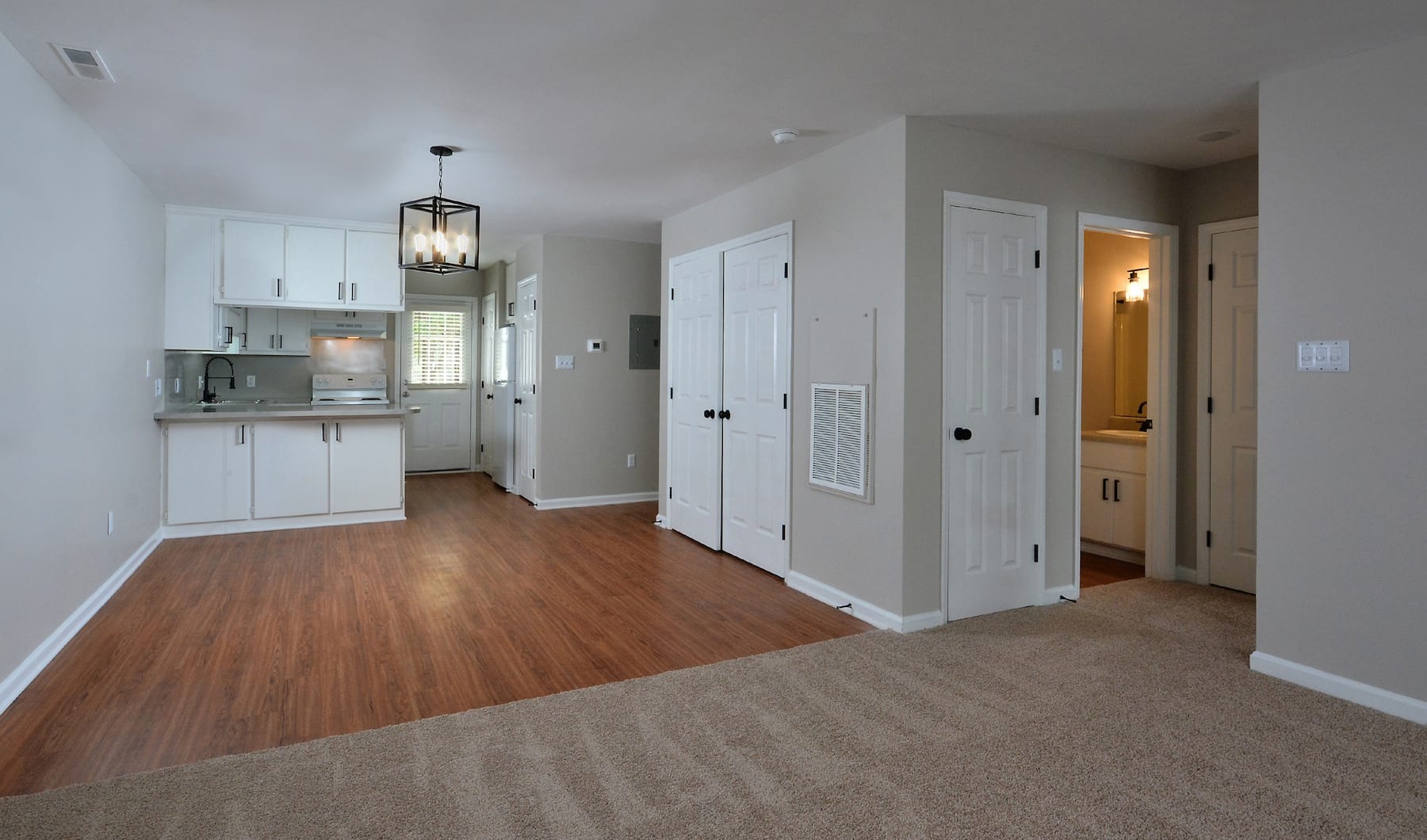 spacious living room that leads into the kitchen and opens up to other rooms through a large hallway
