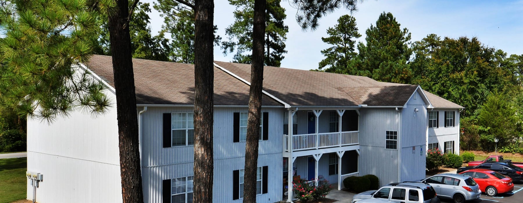 exterior of property with spacious parking and nearby trees