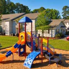 On-site playground with slides and seating at family-friendly apartment community, featuring outdoor recreation space, nearby parking, and a quiet residential setting close to schools, parks, and local shopping